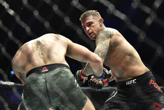 Dustin Poirier punches Conor McGregor of Ireland in a lightweight fight during the UFC 257 event inside Etihad Arena on UFC Fight Island on January 23 2021 in Abu Dhabi UAE (Photo by Chris Unger/Zuffa LLC)